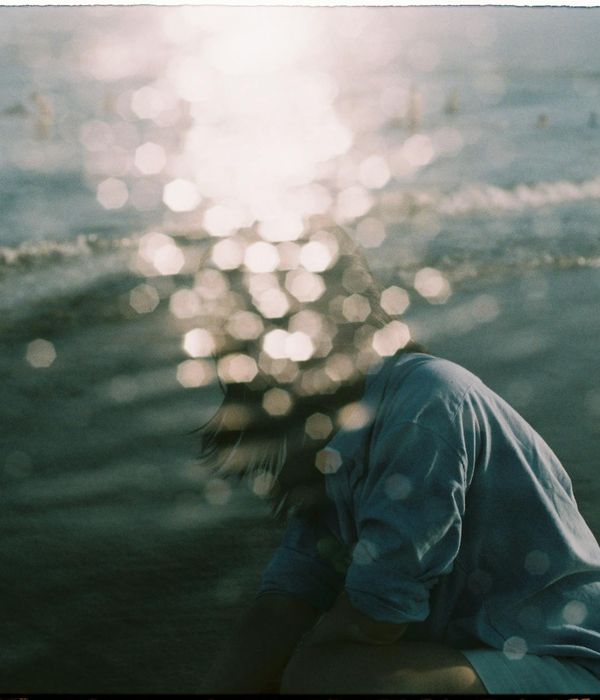 Woman in a calm state with abstract light waves around her.